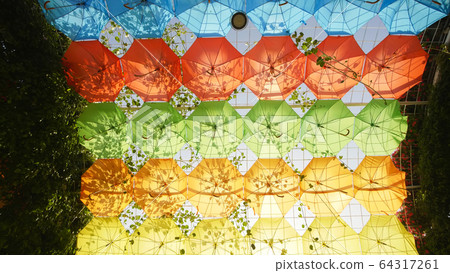 Multi-colored umbrellas in the park of the city. Multi-colored umbrellas in the park of the city. 64317261