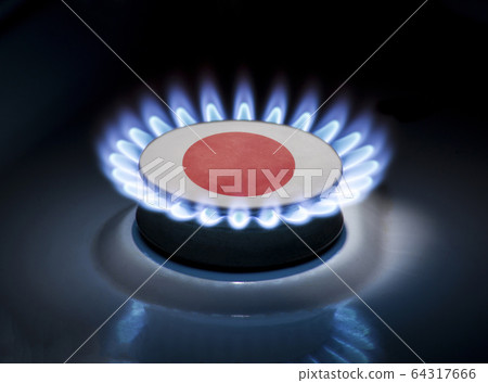 Burning gas burner of a home stove in the middle of which is the flag of the country of Japan. Gas import and export delivery concept, price per cubic meter, transit, background Burning gas burner of a home stove in the middle of which is the flag of the country of Japan. Gas import and export delivery concept, price per cubic meter, transit, background 64317666