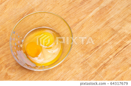 Two chicken eggs, homemade and factory, are broken in a glass plate. Difference concept of homemade natural eggs from store-bought, organic, copy space 64317679
