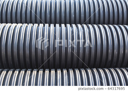 Large diameter black polypropylene pipes for laying communications, drainage systems and heating mains under the road. Modern method and technology for supplying water and sewage, copy space, industry Large diameter black polypropylene pipes for laying communications, drainage systems and heating mains under the road. Modern method and technology for supplying water and sewage, copy space, industry 64317695