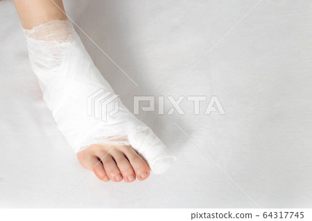 Bandaged big toe with foot on white background. Concept of fracture of the foot and thumb, close-up, copy space 64317745