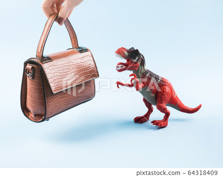 Angry dinosaur toy and lady hand bag 64318409