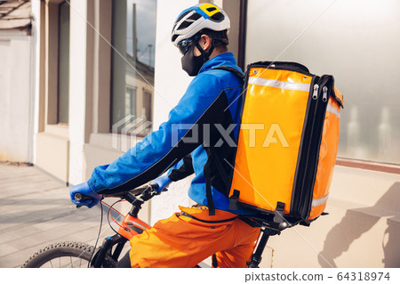 Contacless delivery service during quarantine. Man delivers food and shopping bags during isolation Contacless delivery service during quarantine. Man delivers food and shopping bags during isolation 64318974