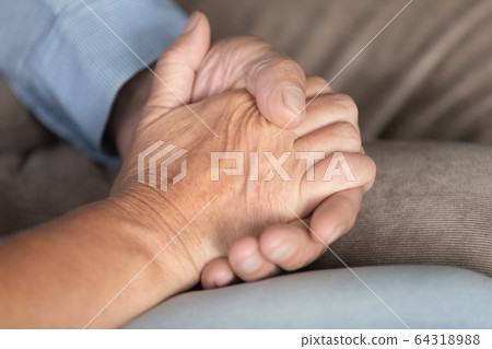 Close up older couple holding hands, supporting and comforting 64318988