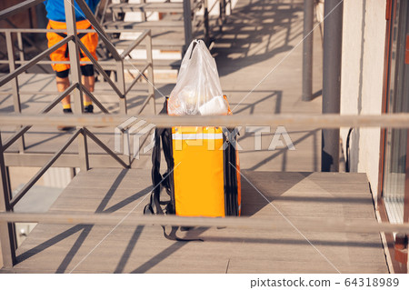 Contacless delivery service during quarantine. Man delivers food and shopping bags during isolation Contacless delivery service during quarantine. Man delivers food and shopping bags during isolation 64318989