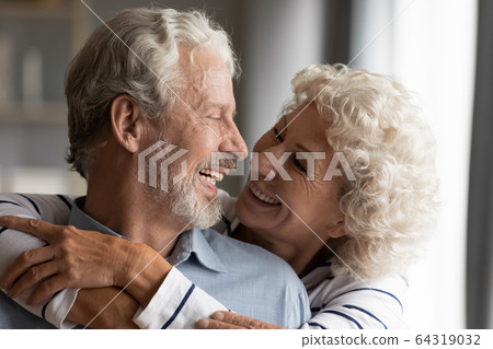 Close up smiling older couple hugging, enjoying tender moment Close up smiling older couple hugging, enjoying tender moment 64319032
