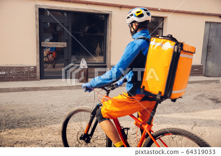 Contacless delivery service during quarantine. Man delivers food and shopping bags during isolation Contacless delivery service during quarantine. Man delivers food and shopping bags during isolation 64319033