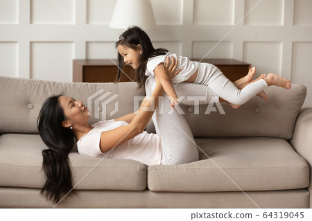 Asian mother play with little daughter in living room Asian mother play with little daughter in living room 64319045
