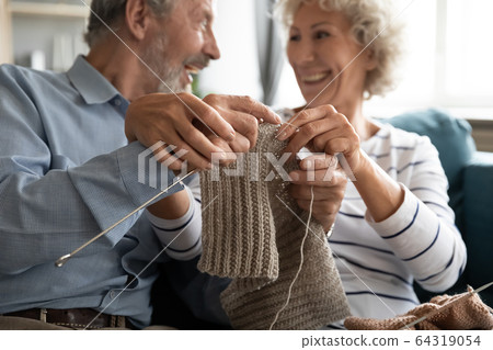 Caring loving older wife teaching husband knitting close up Caring loving older wife teaching husband knitting close up 64319054