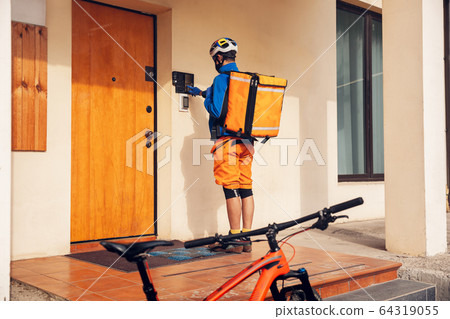 Contacless delivery service during quarantine. Man delivers food and shopping bags during isolation 64319055