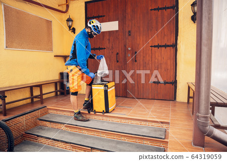 Contacless delivery service during quarantine. Man delivers food and shopping bags during isolation Contacless delivery service during quarantine. Man delivers food and shopping bags during isolation 64319059