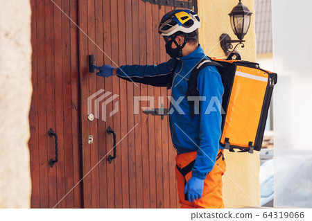 Contacless delivery service during quarantine. Man delivers food and shopping bags during isolation Contacless delivery service during quarantine. Man delivers food and shopping bags during isolation 64319066