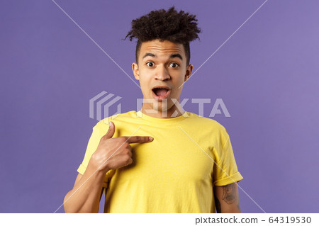 Who me, no way. Portrait of surprised, happy rejoicing young man looking with disbelies as being chosen from all candidates, pointing at himself open mouth fascinated, purple background 64319530