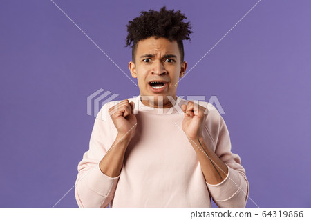 Close-up portrait of worried, anxious funny hispanic man jumping from fear, gasping look concerned, starting to panic before important meeting, standing purple background afraid and nervous 64319866