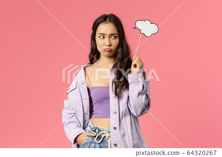 Holidays, lifestyle and people concept. Portrait of gloomy uneasy asian female dont know any idea, sulking and looking away upset of lacking good plan, hold thinking cloud stick nead head 64320267