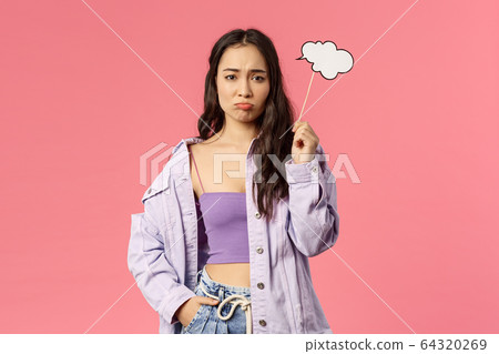 Holidays, lifestyle and people concept. Portrait of gloomy, sulking asian girl dont have any ideas, holding thinking cloud stick and look upset camera as cant figure out plan, pink background 64320269