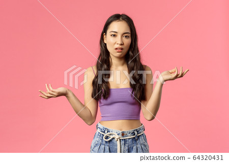 So what. Portrait of careless arrogant stylish asian girl shrugging, raise hands clueless and look camera with skeptical, unimpressed expression, dont care and not see any point, pink background 64320431