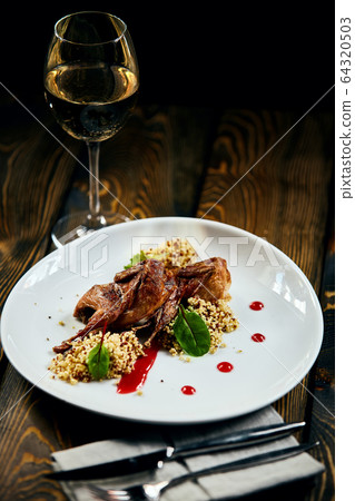 A plate of quinoa quail on a table 64320503