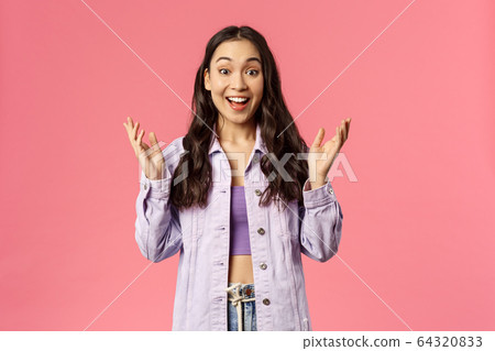 Portrait of surprised, enthusiastic korean girl in denim jacket, look wondered and happy, hear great news, applause, raise hands to clap and praise great work, smiling joyfully, pink background Portrait of surprised, enthusiastic korean girl in denim jacket, look wondered and happy, hear great news, applause, raise hands to clap and praise great work, smiling joyfully, pink background 64320833