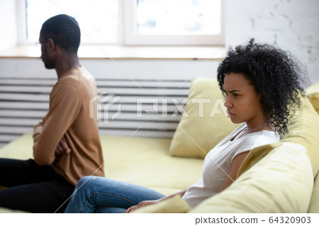 Upset girlfriend feeling guilty after quarrel with African American boyfriend. 64320903