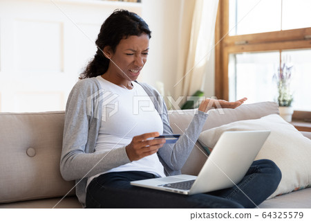 Angry african american girl hold bank card in hand Angry african american girl hold bank card in hand 64325579