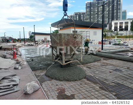 Group of construction workers pouring wet concrete using the mobile crane bucket the construction site. Group of construction workers pouring wet concrete using the mobile crane bucket the construction site. 64326532