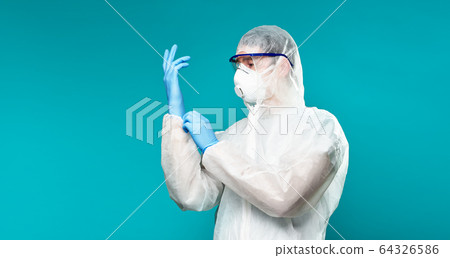 Man in protective suit wearing pritected rubber gloves Man in protective suit wearing pritected rubber gloves 64326586
