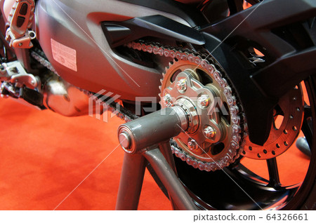 Motorcycle chain. It is a metallic chain that is used to transmit power from the engine to the rear wheel. 64326661