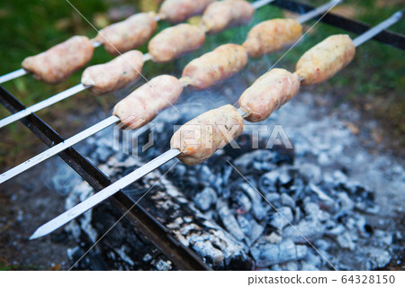 Delicious sausages on a skewer. Rest, friends, Delicious sausages on a skewer. Rest, friends, 64328150