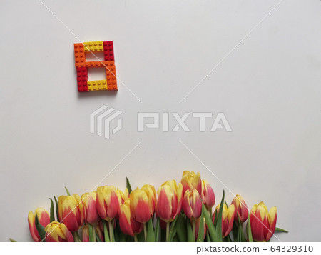 Red and yellow tulips with number eight. Top view of the white background of the spring composition. 64329310