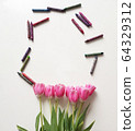 Pink tulips with colored children's pencils. Top view of a spring bouquet on a white background. 64329312