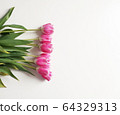 Pink tulips with colored children's pencils. Top view of a spring bouquet on a white background. 64329313