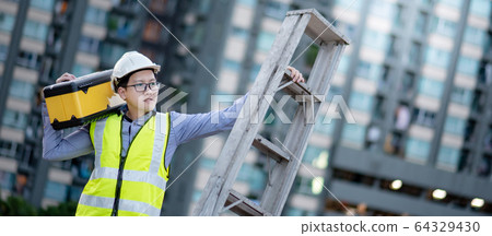 Worker man carrying aluminium ladder and tool box Worker man carrying aluminium ladder and tool box 64329430