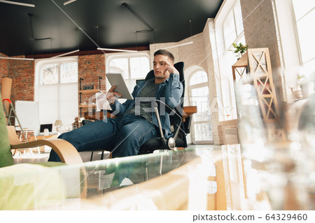 Creative workplace - organized work space as you like for inspiration, man working in office in relaxed posture Creative workplace - organized work space as you like for inspiration, man working in office in relaxed posture 64329460