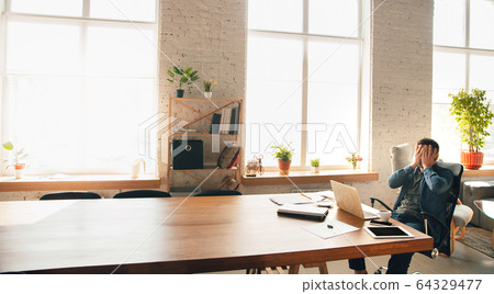 Creative workplace - organized work space as you like for inspiration, man working in office at the huge clear table Creative workplace - organized work space as you like for inspiration, man working in office at the huge clear table 64329477