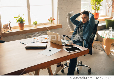 Creative workplace - organized work space as you like for inspiration, man working in office in relaxed posture Creative workplace - organized work space as you like for inspiration, man working in office in relaxed posture 64329478