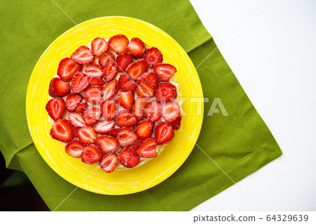 Beautiful strawberry cake is on the table, green 64329639