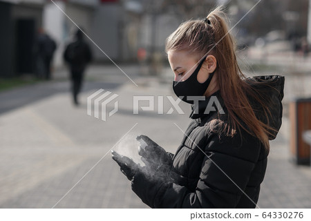 Hand of woman is spraying alcohol,disinfectant spray on mobile phone,prevent infection of Covid-19 virus,contamination of germs or bacteria,wipe or cleaning phone to eliminate,outbreak of Coronavirus 64330276