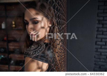 Beautiful seductive girl in sexaual leather dress. Beautiful seductive girl in sexaual leather dress. 64330362