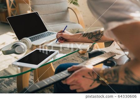 Young man studying at home during online courses or free information by hisself Young man studying at home during online courses or free information by hisself 64330606