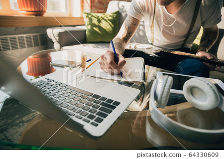 Young man studying at home during online courses or free information by hisself Young man studying at home during online courses or free information by hisself 64330609