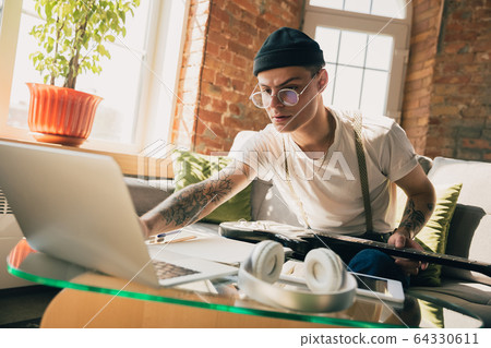 Young man studying at home during online courses or free information by hisself Young man studying at home during online courses or free information by hisself 64330611