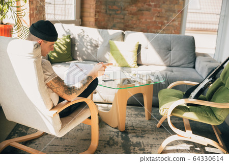 Young man studying at home during online courses or free information by hisself Young man studying at home during online courses or free information by hisself 64330614