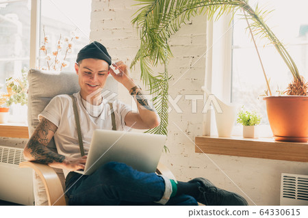 Young man studying at home during online courses or free information by hisself, online school Young man studying at home during online courses or free information by hisself, online school 64330615