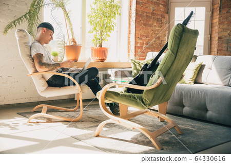 Young man studying at home during online courses or free information by hisself, online school 64330616