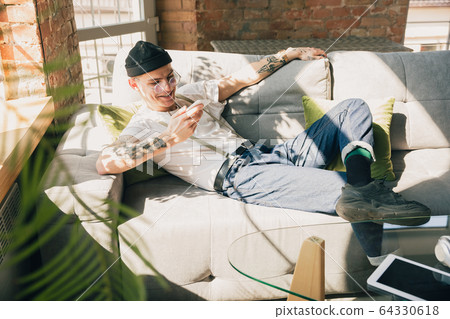 Young man studying at home during online courses or free information by hisself, online school 64330618