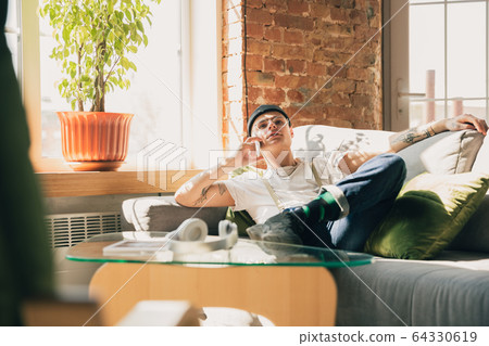 Young man studying at home during online courses or free information by hisself, online school Young man studying at home during online courses or free information by hisself, online school 64330619