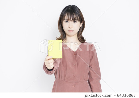 A woman giving out a yellow card 64330865