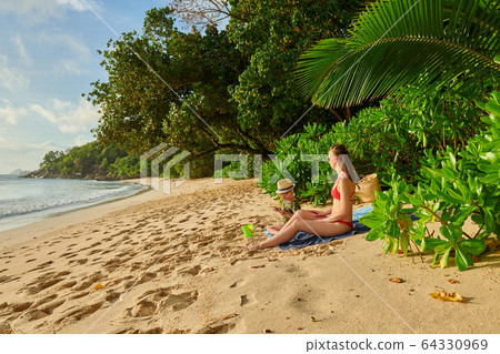 Toddler boy on beach with mother Toddler boy on beach with mother 64330969