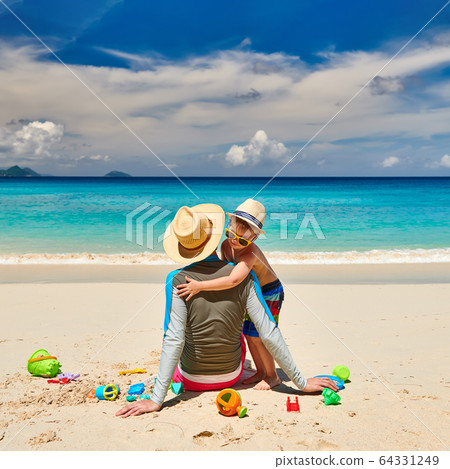 Toddler boy on beach with father Toddler boy on beach with father 64331249